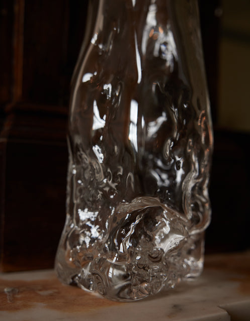 Blown vase | Glass: A free-form clear-glass vessel with fluid, sculptural contours, reflecting light on a marble surface, embodying Szkło Studio's unique craftsmanship.
