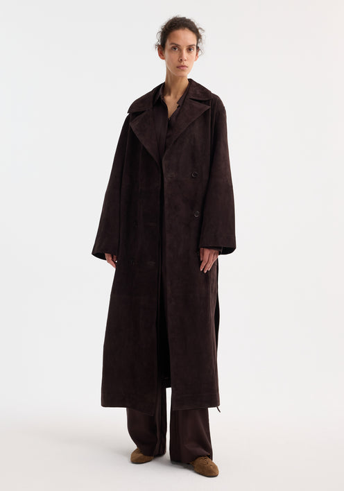 Model in a suede belted wrap coat, dark chocolate, with wide lapels and patch pockets, paired with matching trousers and light brown suede lace-up shoes.