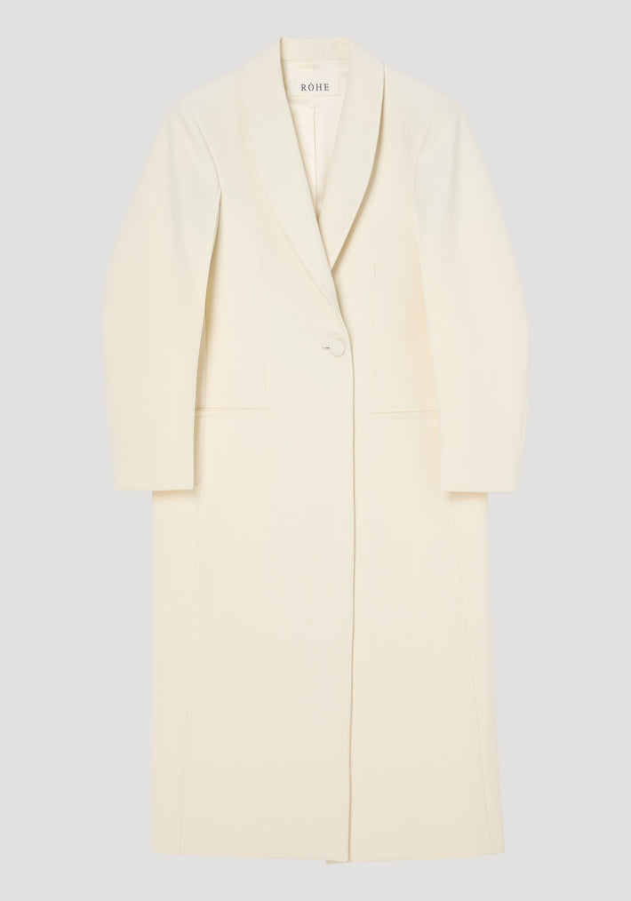 Signature opera coat | ivory: Long, single-breasted coat with a shawl collar, single button, mid-calf length, horizontal pockets, and center back slit. Elegant structured silhouette.