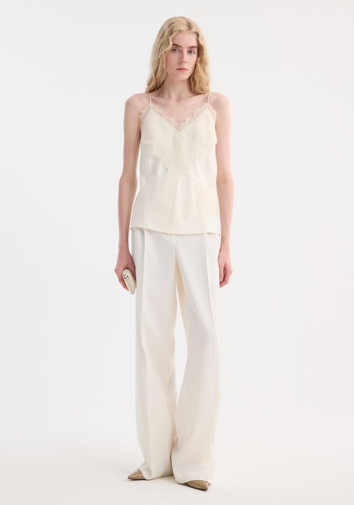 Lace camisole | cream: A tall woman models an ivory silk camisole with lace trim and adjustable straps, paired with matching high-waisted trousers and a clutch.