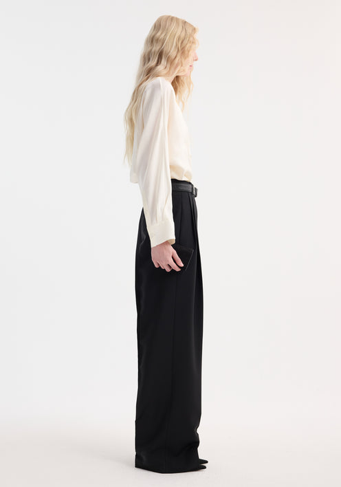 Model wearing a Relaxed fit button down top | cream, featuring double-breasted button closure, pointed collar, tucked into high-waisted wide-leg trousers.