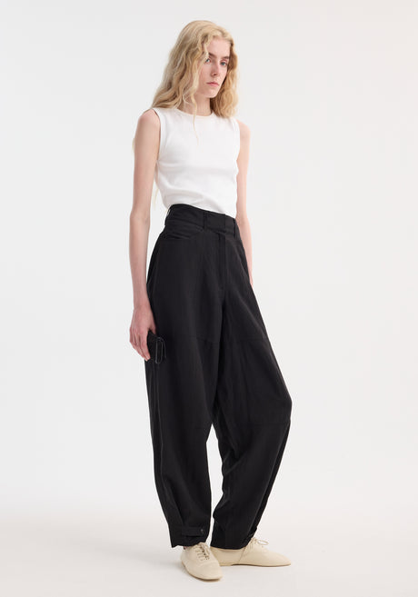 Model in Parachute trousers | black, featuring high-waisted, wide-leg design with tapered cuffs, paired with a rib-knit top and beige lace-up shoes.