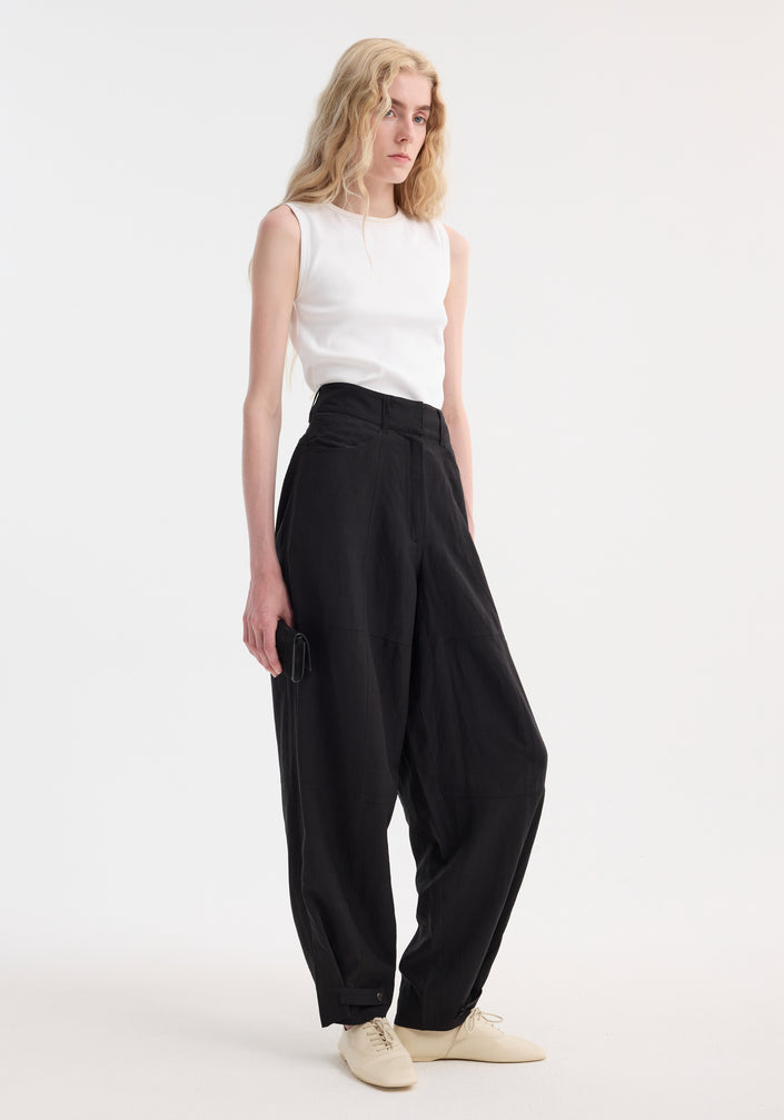 Model in Parachute trousers | black, featuring high-waisted, wide-leg design with tapered cuffs, paired with a rib-knit top and beige lace-up shoes.