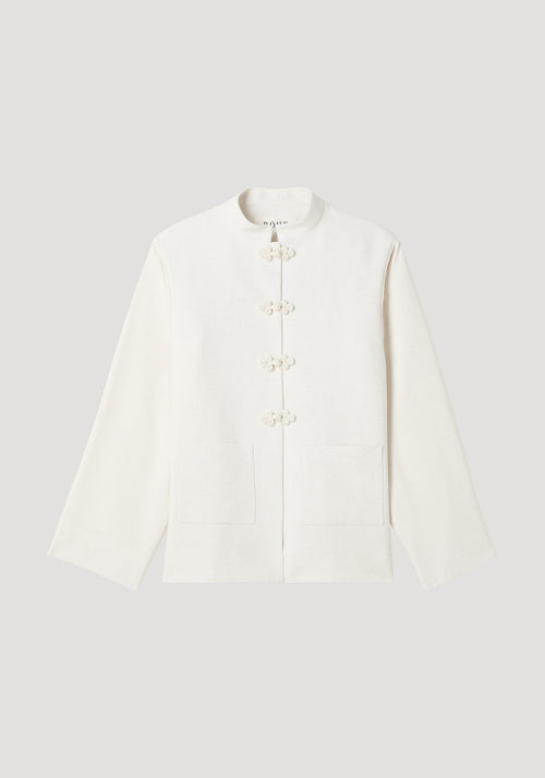 Mandarin jacket | winter white with a boxy cut, stand-up collar, frog closures, patch pockets, and wide sleeves. Made from a textured silk blend fabric.