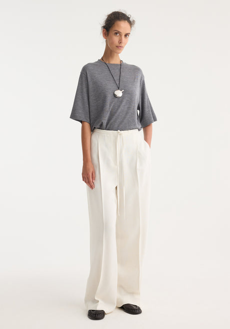 Relaxed drawstring trousers in winter white, featuring a wide-leg silhouette and a drawstring waistband, crafted from a soft silk blend fabric for comfort.