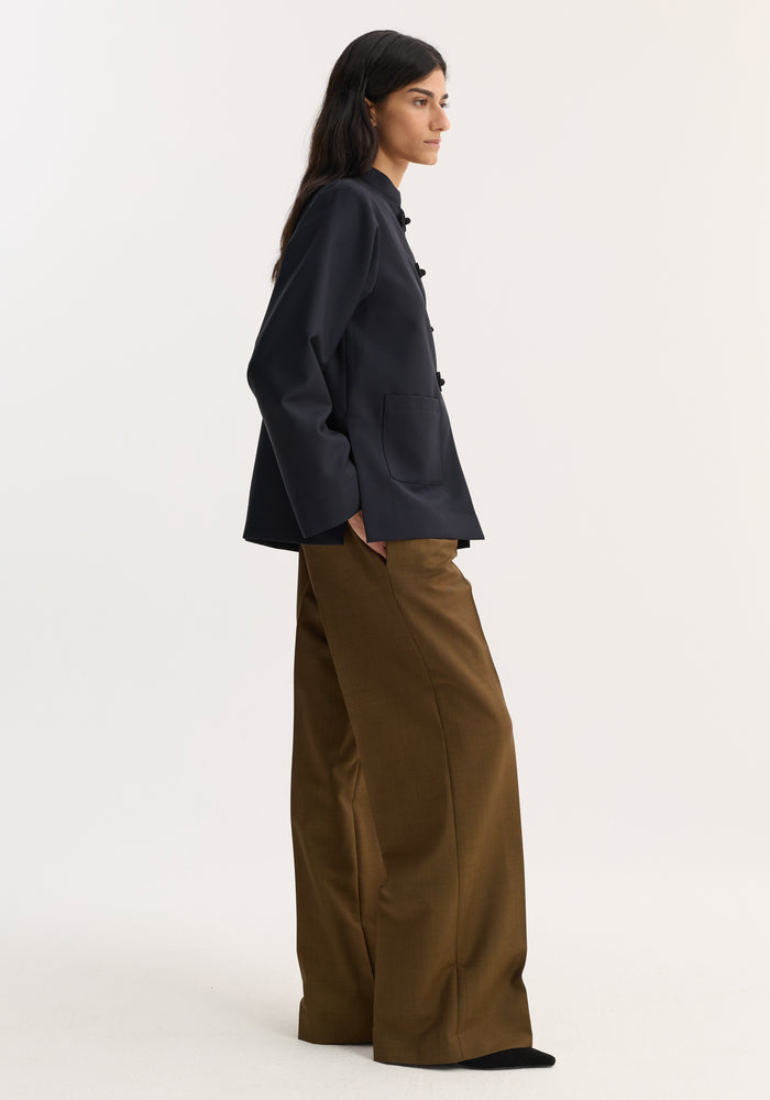 Mandarin jacket | navy: Woman in profile wears a navy wool-mohair jacket with pankou closures and patch pockets, paired with high-waisted, wide-leg trousers.