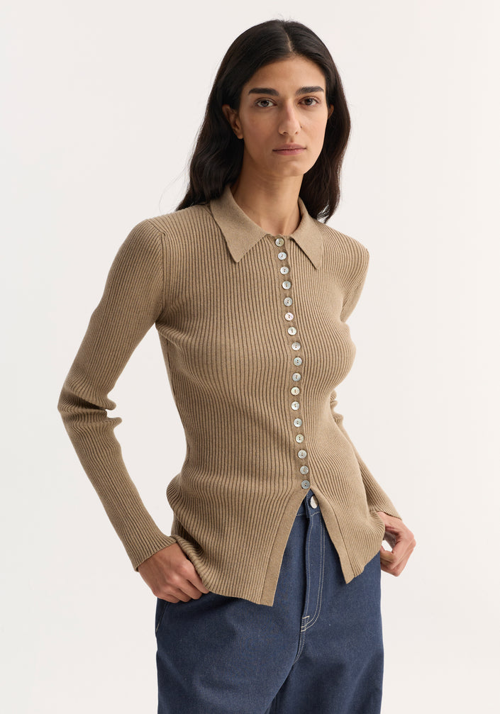Elongated rib cardigan in taupe melange with a fitted silhouette, pointed collar, and white buttons, paired with wide-leg jeans and black sandals.