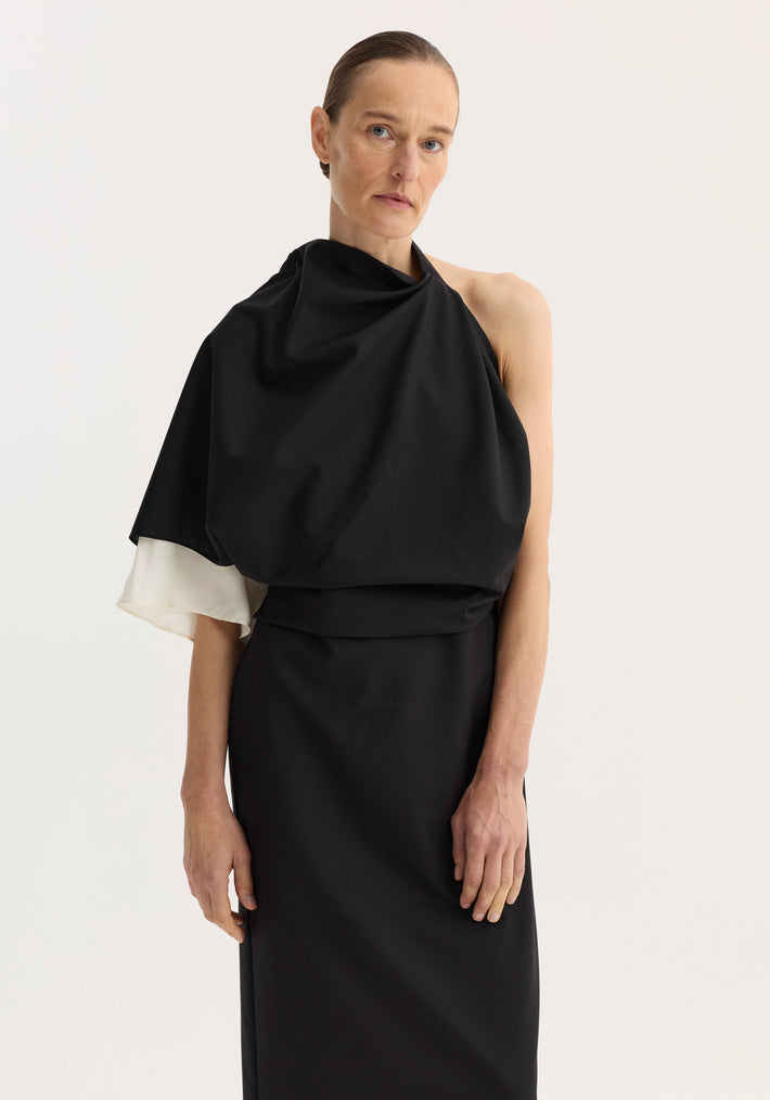 Woman wearing Draped open back dress | black, featuring a one-shoulder design, single sleeve, and back slit, with a subtle contrasting silk insert.