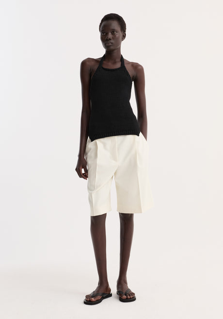 Chunky knit halter top | black, worn by a model, features a fitted design, side slits, and a neck button closure for comfort.