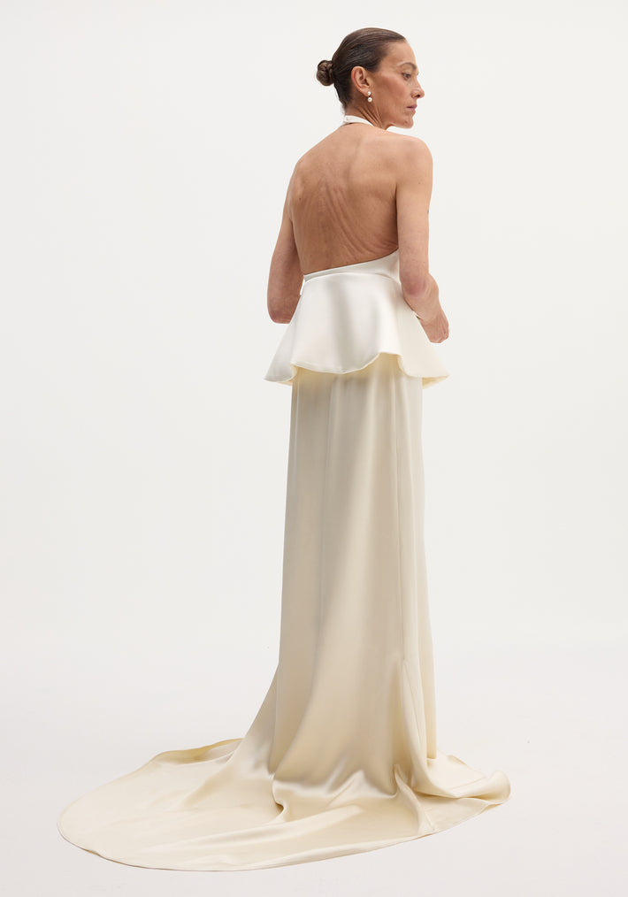 Sculptural satin halter top with separate silk skirt in ivory, showcasing a backless design, peplum waist, and elegant floor-length train.