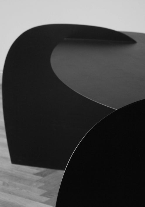 Sculpted Table | 9845: Two matte-black, abstract oak tables by Arne Kristian, showcased in a spacious room with herringbone floors and natural light through a large window.