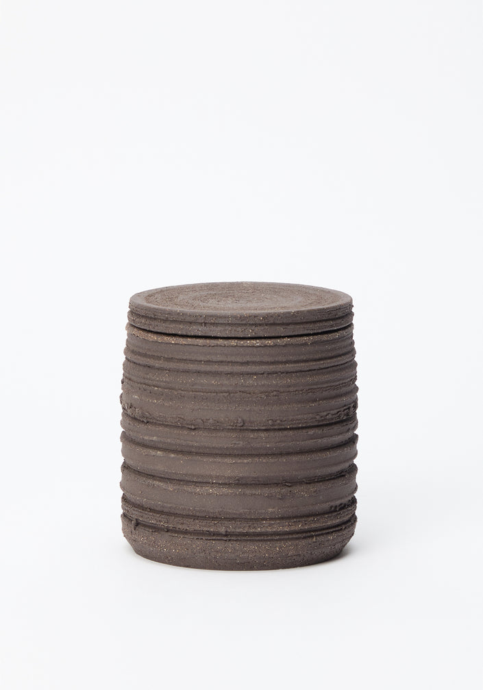 Diplomatico Scented Candle | soil in a handmade ceramic vessel with horizontal ridges, featuring a brutalist design, infused with a woody-aromatic fragrance.