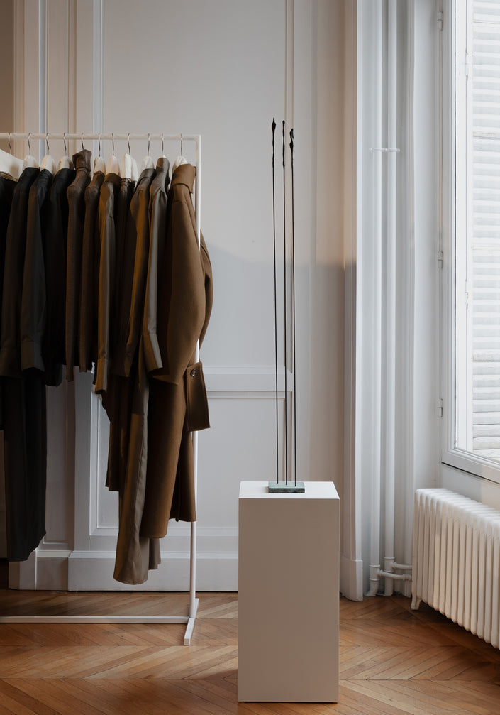 Bronze Sculpture | Dialogue: A slender abstract bronze sculpture by artist Veri Wisman, featuring thin vertical rods on a pedestal, adding charm to a minimalist interior.