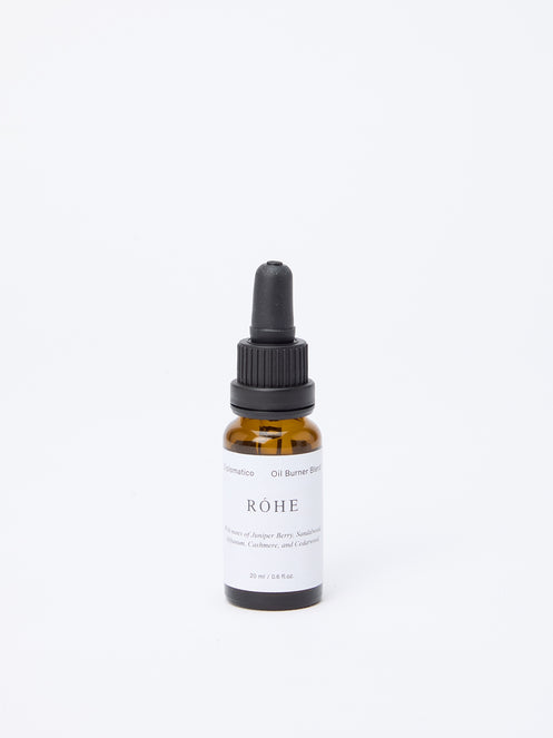 Diplomatico Burner Oil: A 20 ml amber-glass dropper bottle labeled “RÓHE,” featuring woody-aromatic notes like juniper, sandalwood, and cedarwood for Róhe’s Oil Diffuser.