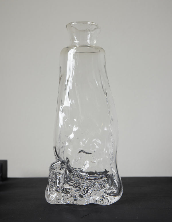 Blown vase | Glass: A unique, hand-blown clear glass vessel with an organic base, tapering into a narrow neck and flared mouth, crafted by Szkło Studio.