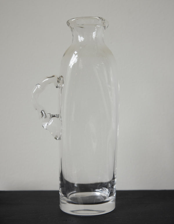 Large water carafe | Glass: A tall, clear glass vessel with a unique, irregular handle, showcasing Szkło Studio's experimental, hand-blown craftsmanship.