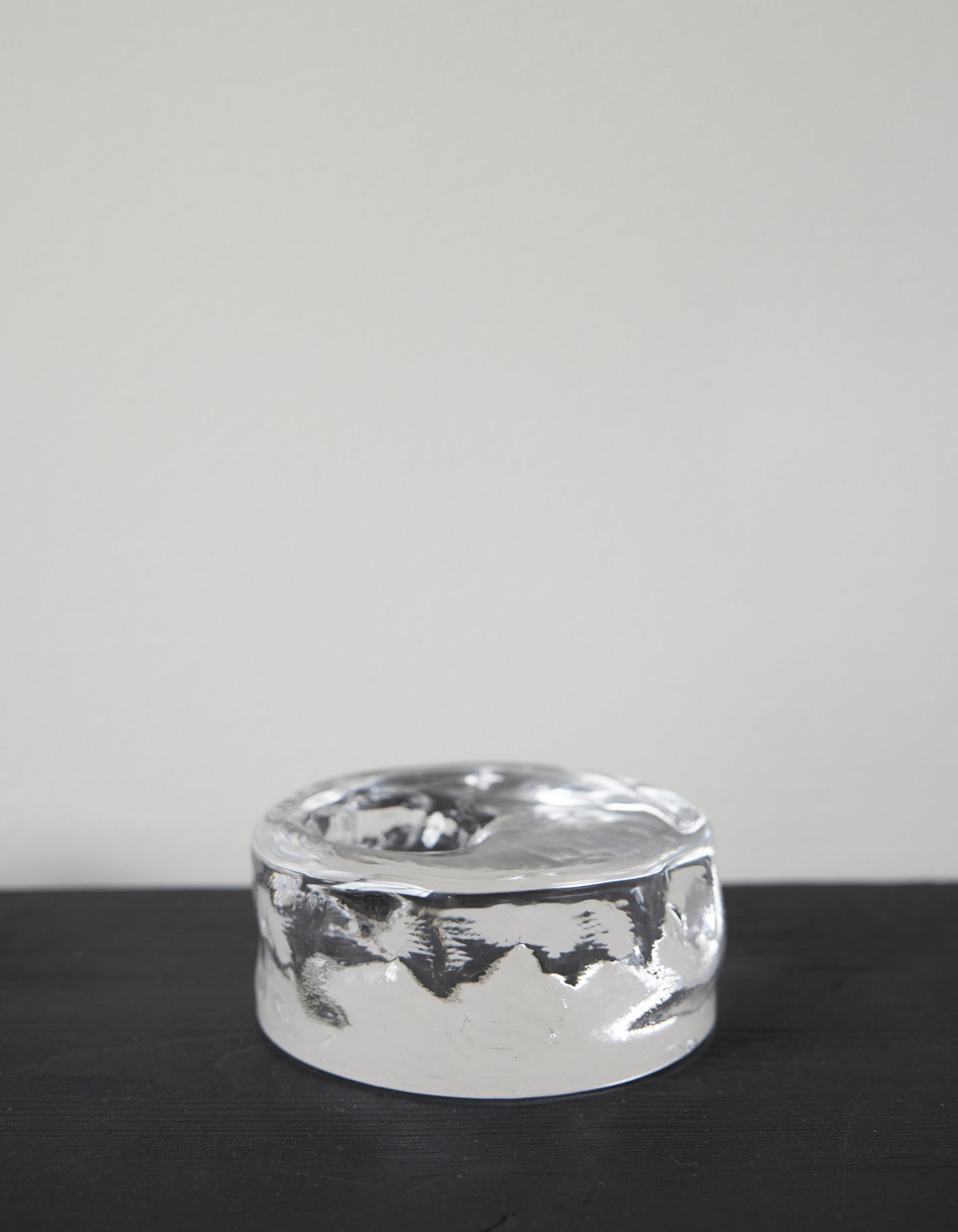 Presse-papier & holder | Glass: A small, polished silver metal object with a melted texture and shallow dish top, showcasing minimalist, sculptural design.