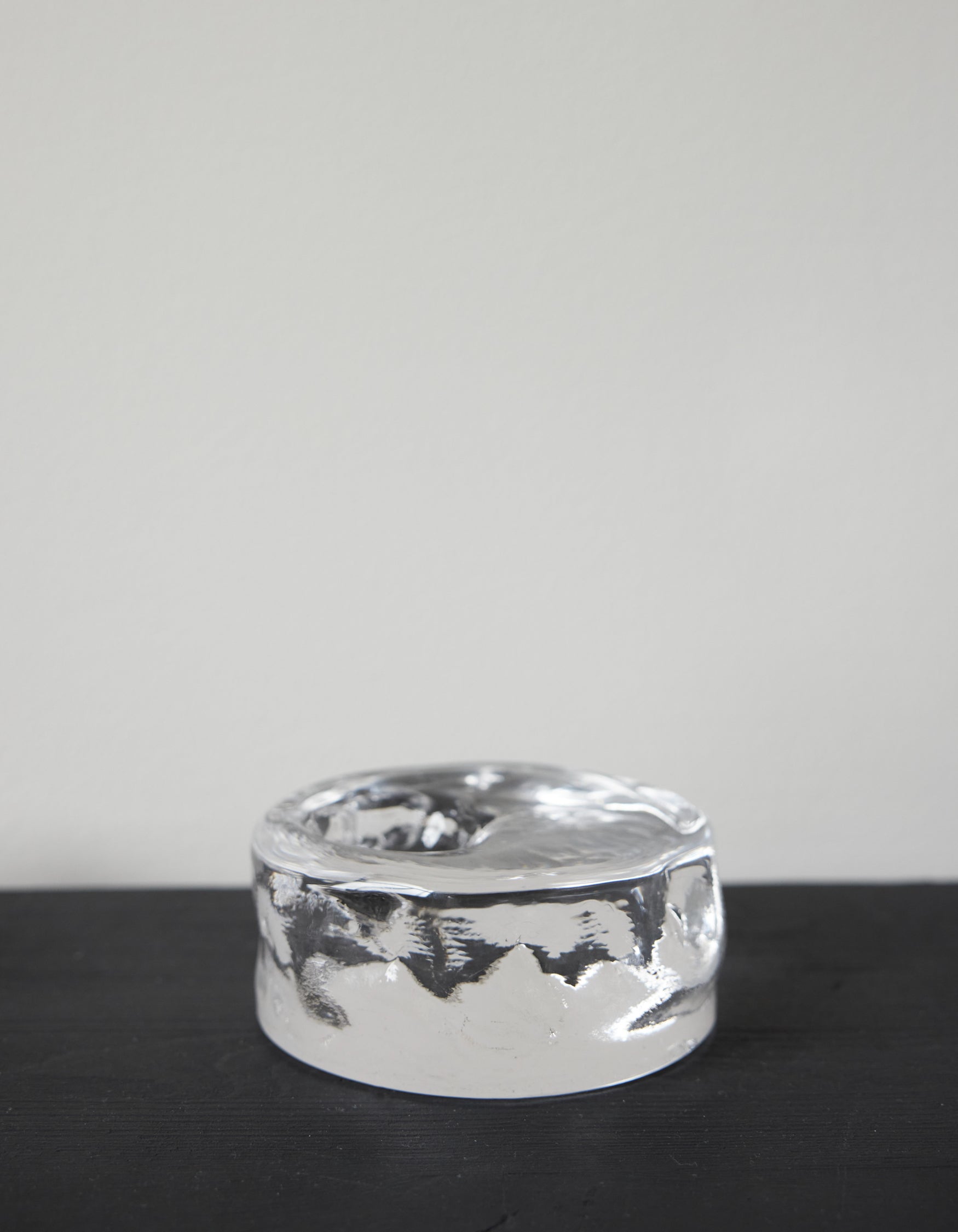 Presse-papier & holder | Glass: A small, polished silver metal object with a melted texture and shallow dish top, showcasing minimalist, sculptural design.