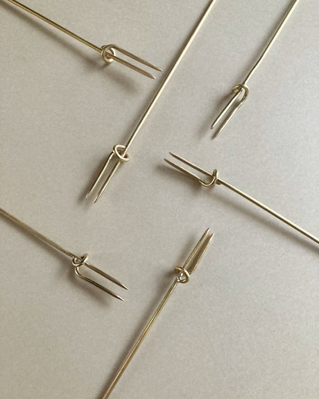 Vine Fork: Handcrafted gold-tone metal skewers with two prongs and a sliding ring, designed by Kyoto artist Nikke Misae for securing appetizers.