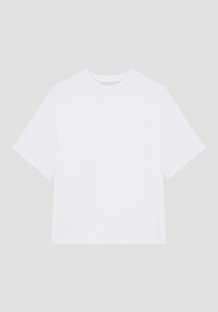 White oversized cotton t-shirt with short sleeves and a round neckline, displayed flat on a neutral background, featuring the 
