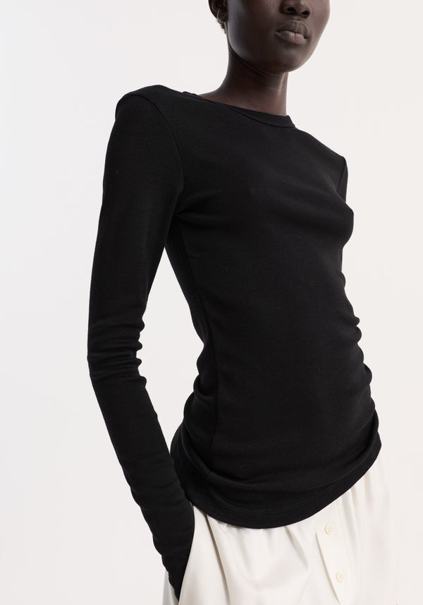 Fine merino long sleeve | black, worn with high-waisted trousers, showcases a fitted silhouette and crew neck, crafted from 100% merino wool for versatile styling.