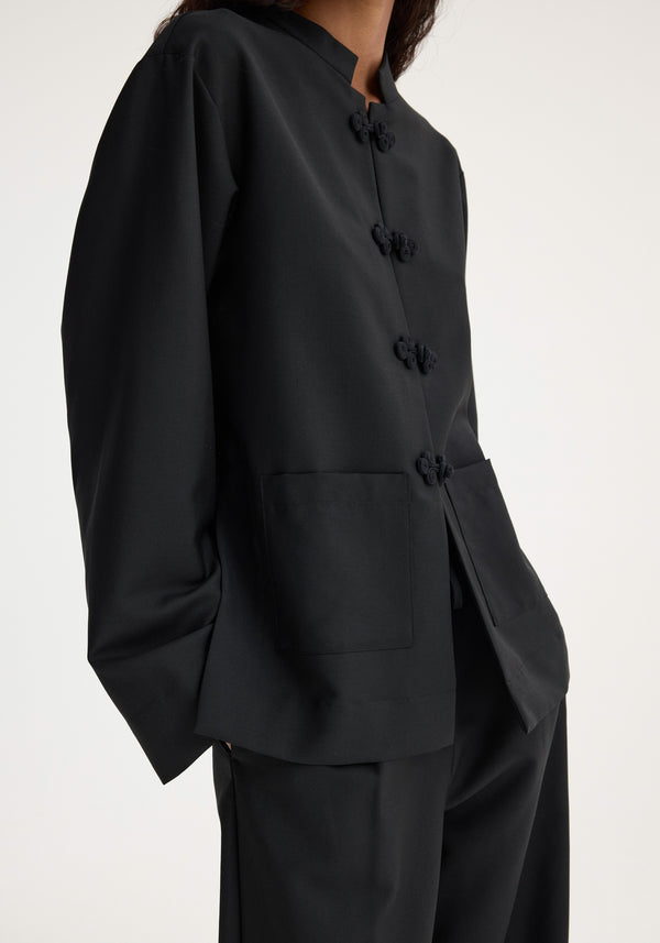 Mandarin jacket | black featuring a mandarin pankou closure, patch pockets, and crafted from a virgin wool-mohair blend, worn with matching trousers.