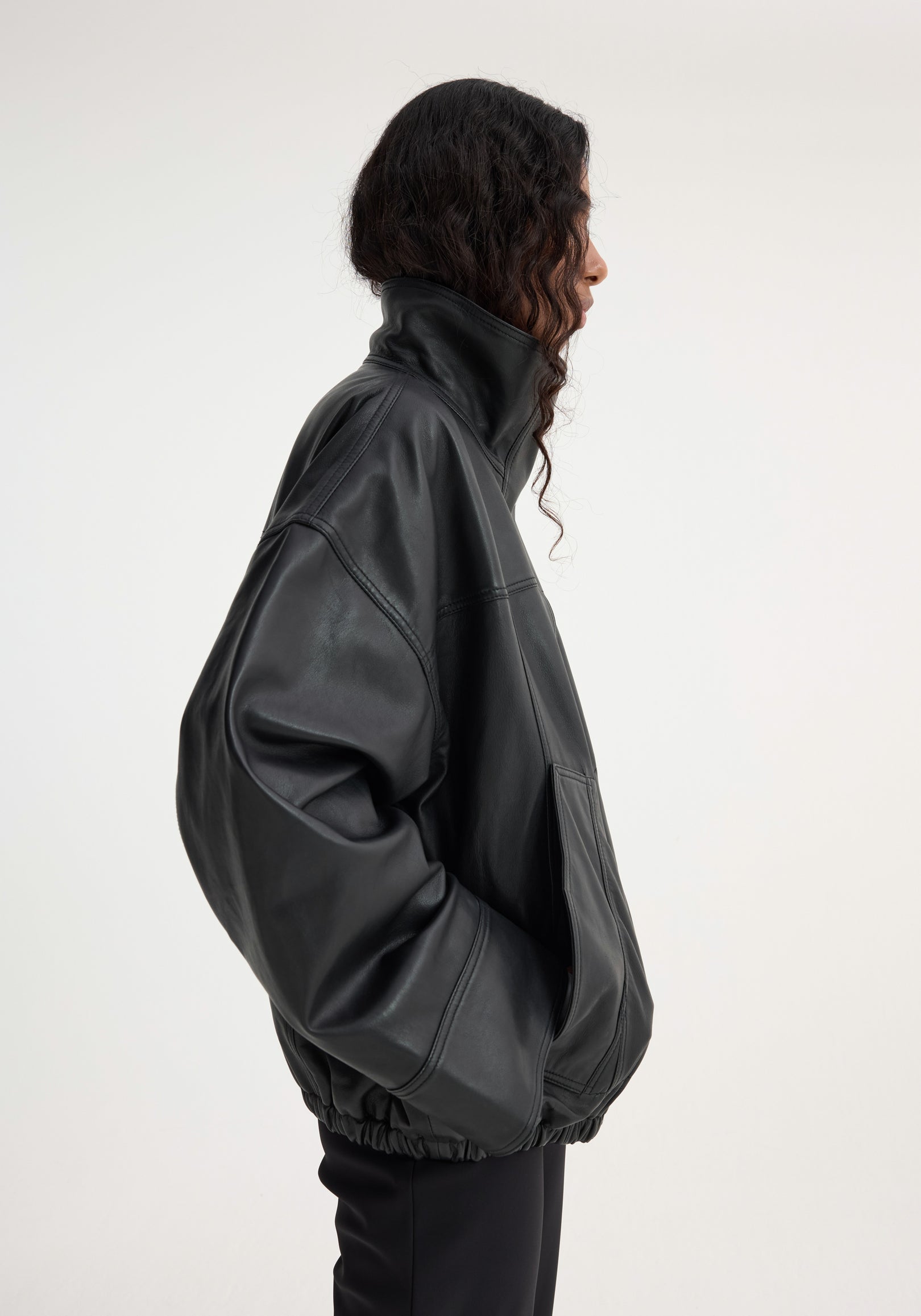 Reinvented leather jacket | black, featuring a tall collar, roomy sleeves, and elasticated hem, worn oversized with a relaxed, bomber-style silhouette.