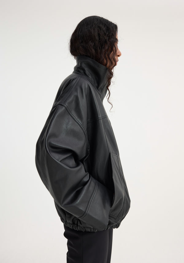 Reinvented leather jacket | black, featuring a tall collar, roomy sleeves, and elasticated hem, worn oversized with a relaxed, bomber-style silhouette.