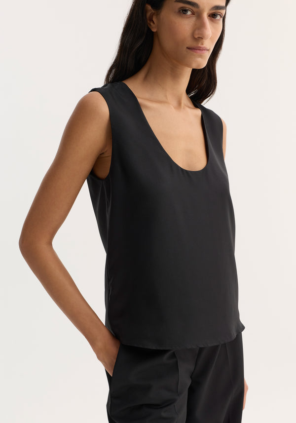 Model wearing a Scoop-neck silk top in black, showcasing a wide scoop neck and loose fit, crafted from 100% pure silk for minimalist layering.