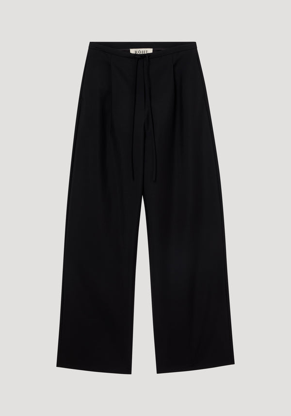 Relaxed drawstring trousers in black, featuring a wide-leg design with subtle front pleats, drawstring waistband, and back welt pockets, crafted from a wool-mohair blend.