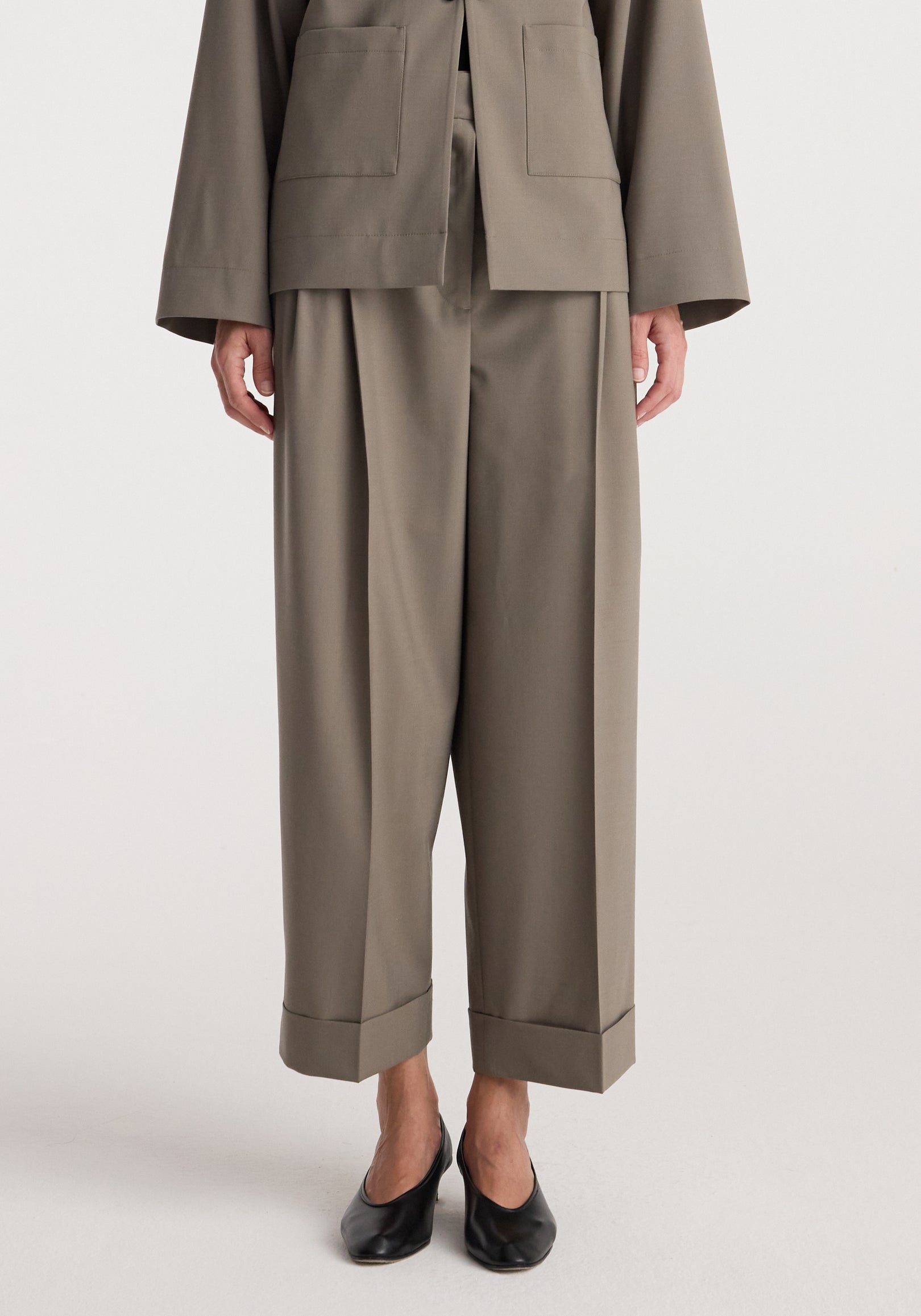 High-waist turn-up trousers | taupe shown on a model wearing black pointed-toe shoes, featuring wide straight legs and a relaxed fit with cuffed hems.