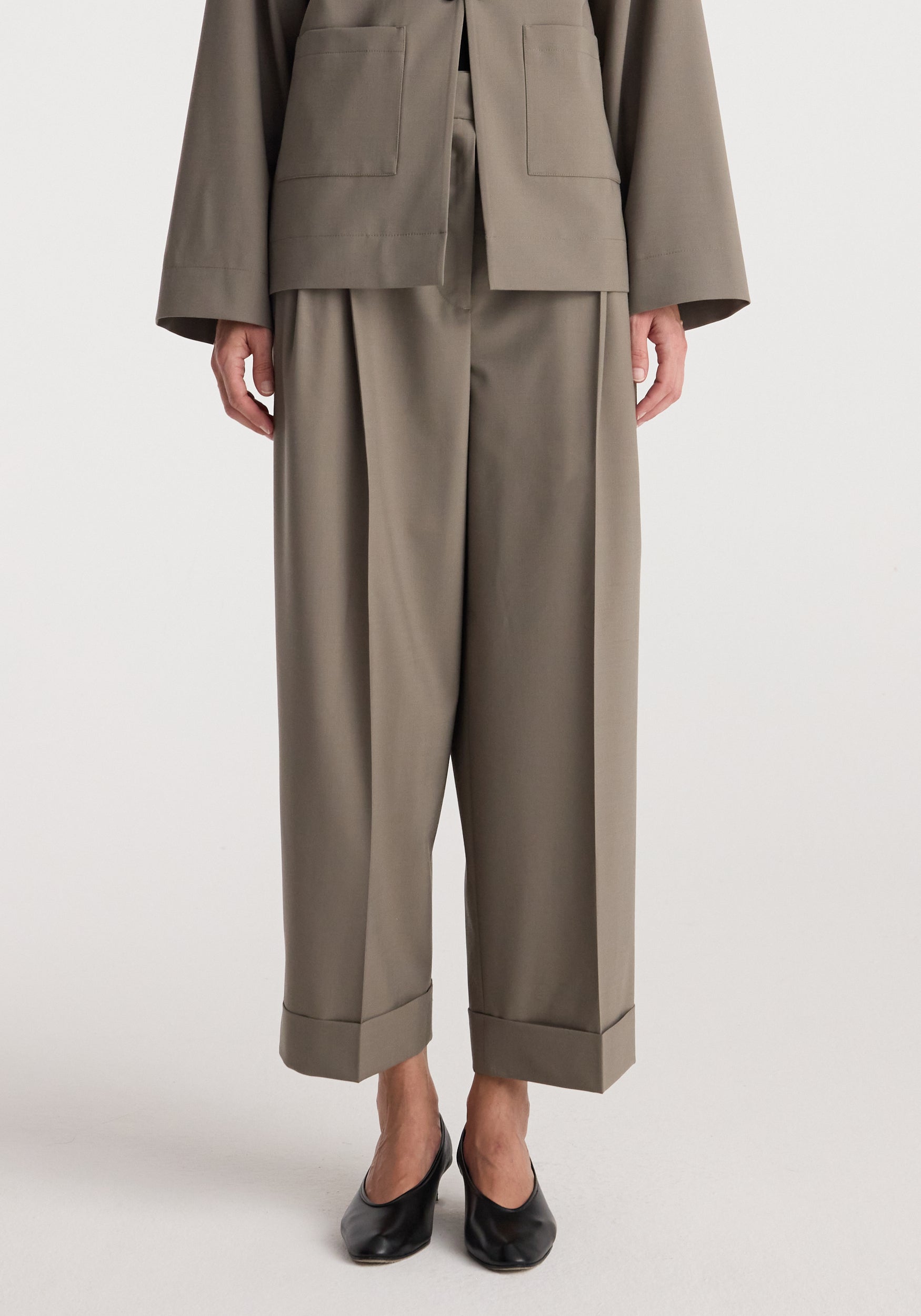 High-waist turn-up trousers | taupe shown on a model wearing black pointed-toe shoes, featuring wide straight legs and a relaxed fit with cuffed hems.