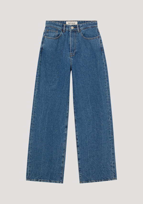 Signature baggy fit denim in mid denim blue, featuring wide-leg cut, high-waisted style, button-and-zip fly, and five-pocket design with RÖHE label on waistband.