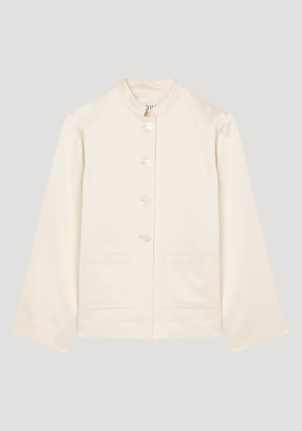Pearl button satin jacket in cream featuring a mandarin collar, four pearl buttons, and hip patch pockets. Laid flat, highlighting its elegant, soft satin texture.
