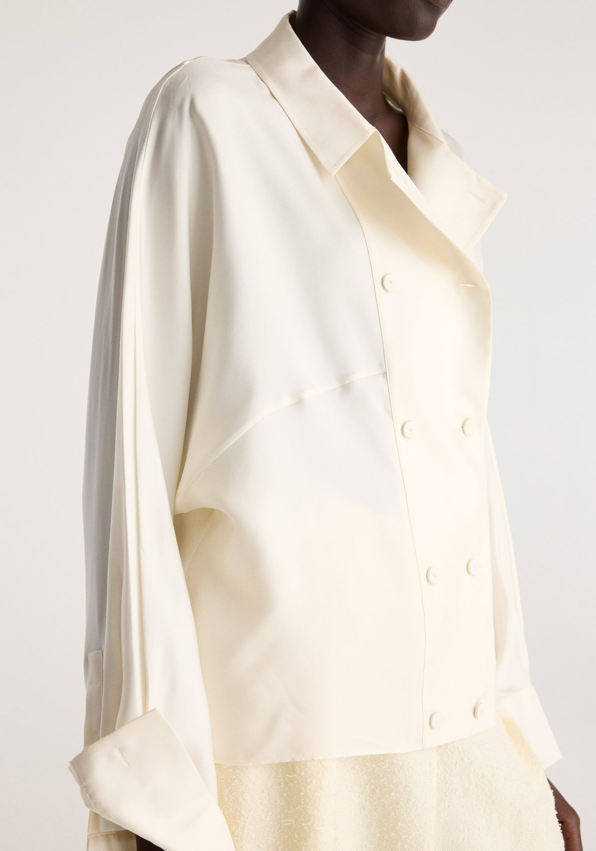 Double breasted silk top | cream shown on a model with a pointed collar long sleeves and double button front
