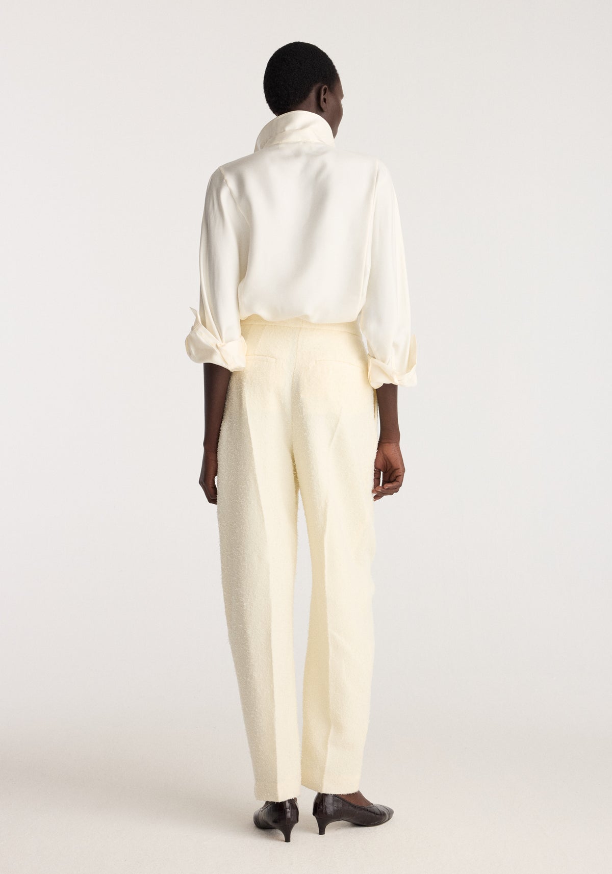 Puck - Sculptural bouclé tailored trousers | cream shown from the back on a model wearing a white blouse and black shoes