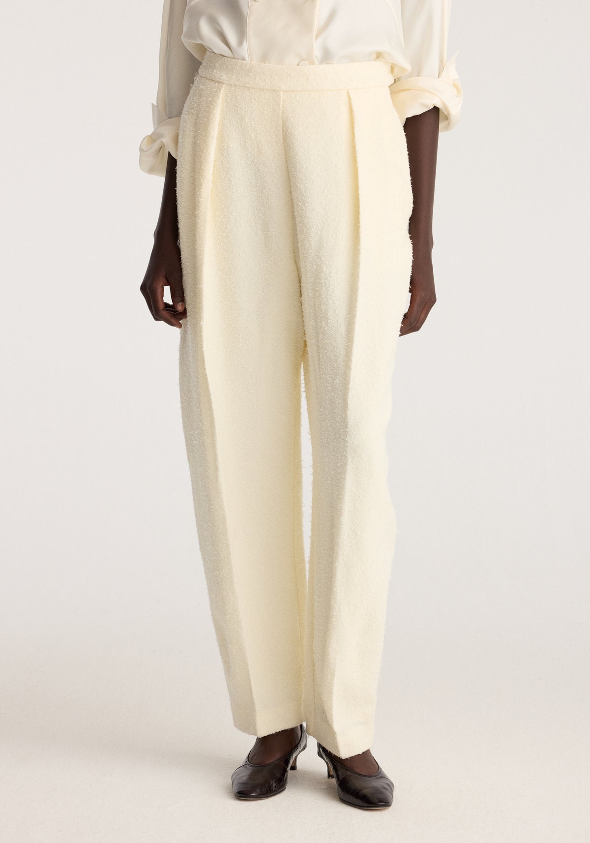 Puck - Sculptural bouclé tailored trousers | cream shown on a model with a relaxed straight leg fit and tailored waistband styled with a white blouse and black shoes
