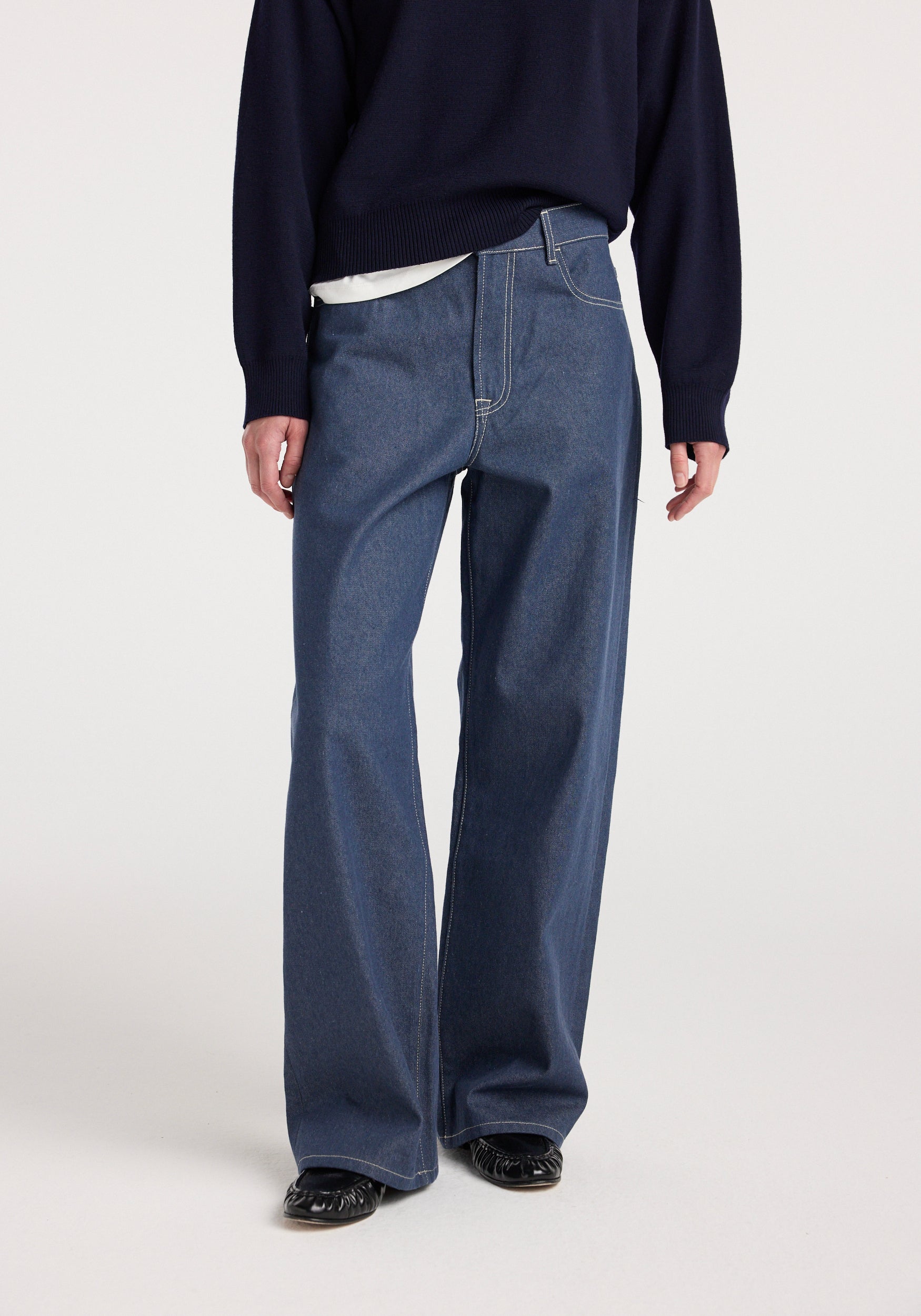 Model wearing Bruun - Signature baggy denim | raw denim trousers paired with a dark sweater and black shoes, showcasing the relaxed fit and straight leg design.
