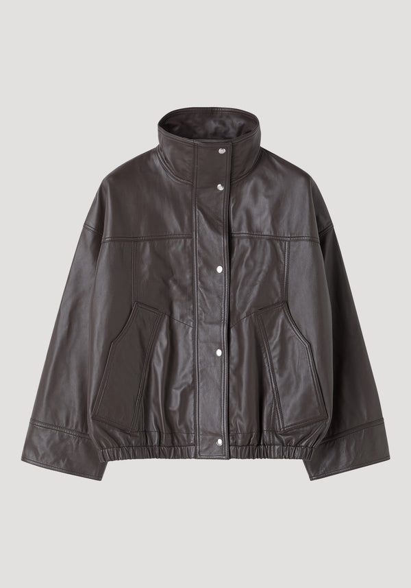 Reinvented leather jacket | earth features a dark leather bomber style with a stand-up collar, snap-button front, and elasticized hem, offering a relaxed, oversized fit.