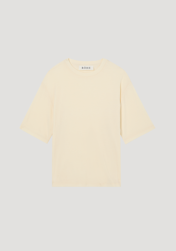 Oversized merino T-shirt in off-white with a boxy cut, crew neck, elbow-length sleeves, and dropped shoulders, showcasing a relaxed fit and luxurious wool fabric.