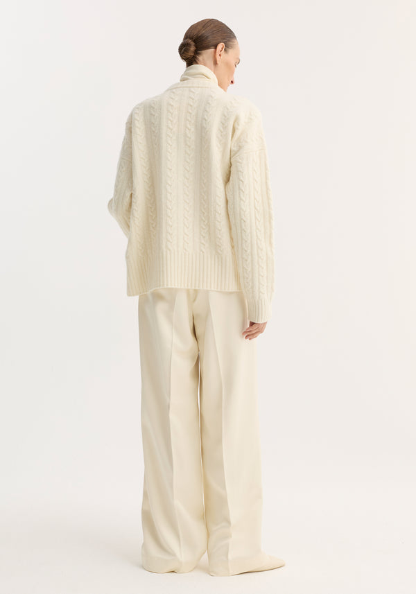 Person wearing an oversized Cable knit jumper | off white with dropped shoulders and round neckline, styled with matching wide-leg trousers, viewed from behind.