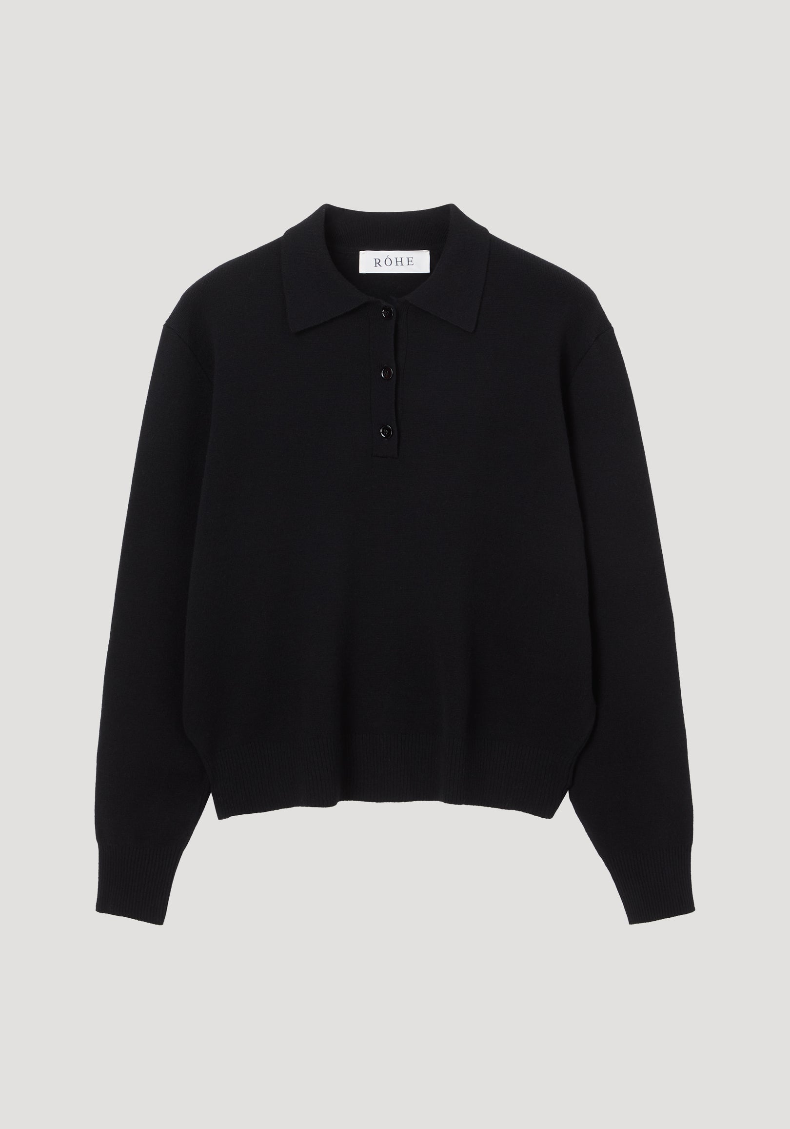 Compact knitted polo | black featuring a structured collar, three-button placket, ribbed cuffs, and hem. Crafted from a wool-cashmere blend with a relaxed, rounded drop shoulder.