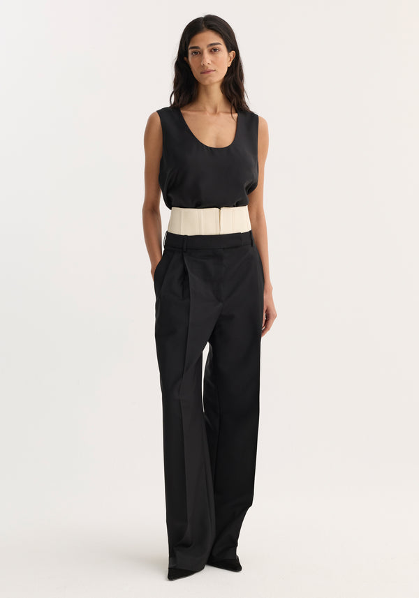 Woman wearing Corset trousers | black with a sleeveless top, featuring a structured cream belt. The tailored, wide-leg pants highlight the corset detail above the waistband.