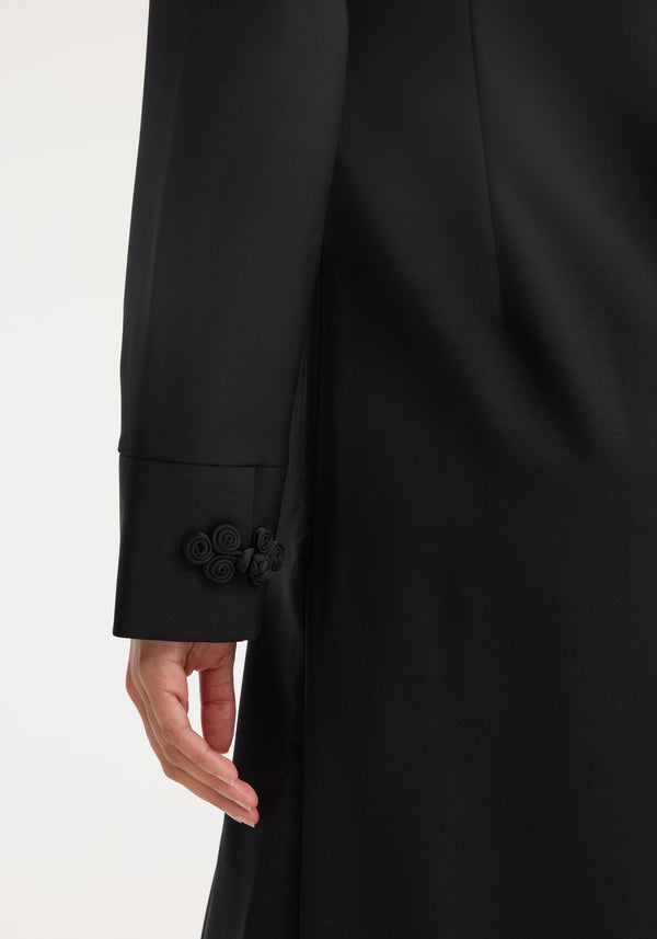Person's arm in a long black garment featuring decorative pankou closures on the sleeve, part of the Pankou closure dress | black.