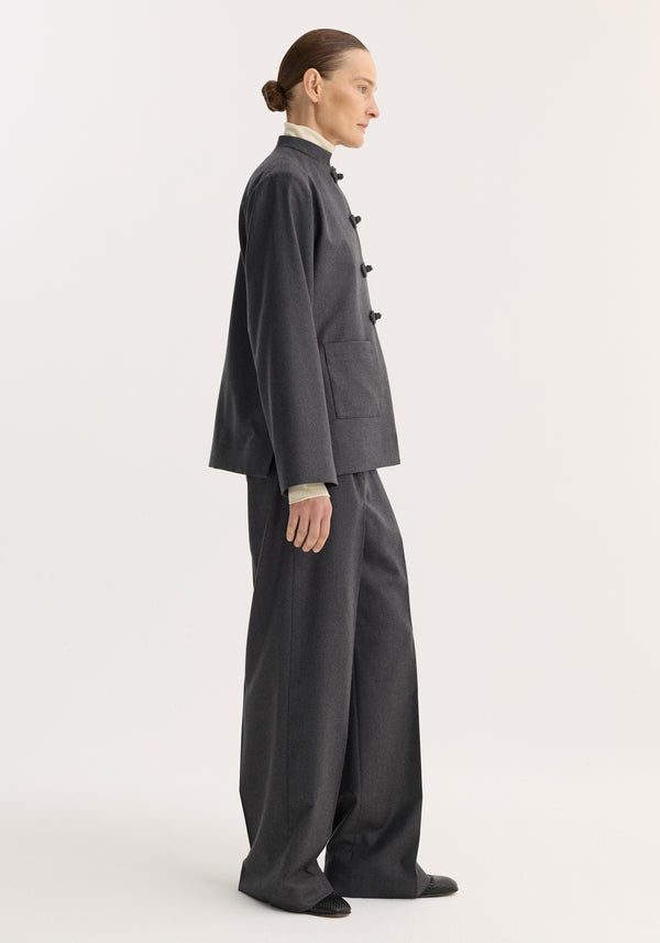 Mandarin jacket in dark grey melange with pankou closure, embroidered edges, and patch pockets, part of a tailored ensemble with matching wide-leg trousers.