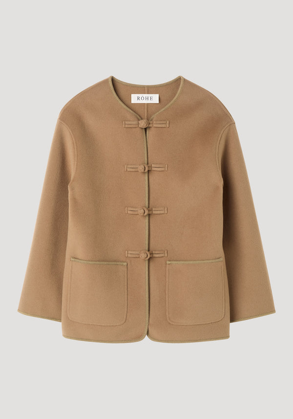 Mandarin double-faced wool jacket in camel with pankou closures, embroidered edges, patch pockets, and a round neckline, made from 95% wool and 5% cashmere.