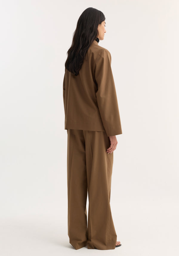 Back view of a woman in a Mandarin Jacket with wide sleeves and pankou closures, paired with matching wide-leg trousers, highlighting minimalist design and flowing silhouette.