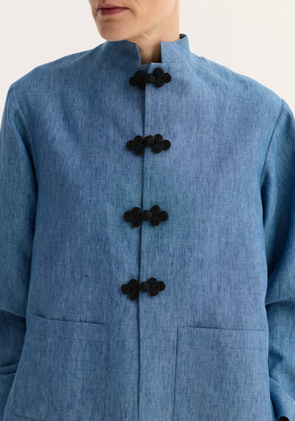 Mandarin jacket in ocean blue, featuring a stand-up collar, black frog closures, embroidered edges, and large patch pockets, made from 100% linen.