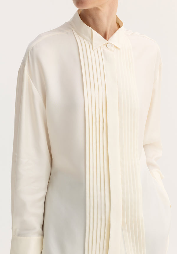 Shaped tuxedo silk shirt | cream: An ivory-cream, long-sleeved blouse with a pointed collar and pleated front panel, showcasing a smooth, lustrous silk texture.
