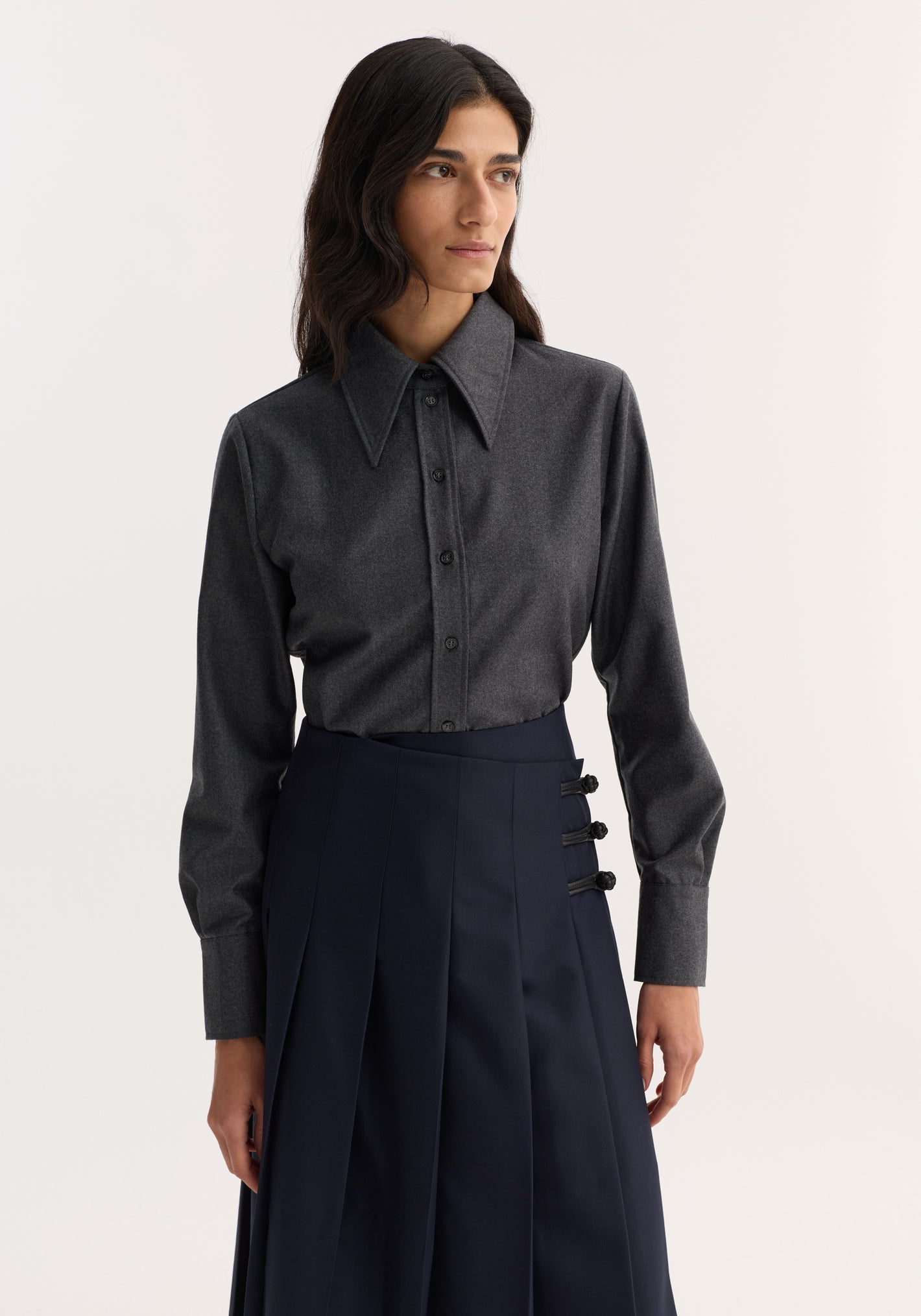 Model wearing Fitted shirt | dark grey melange, featuring a long-sleeved, button-down design with a sharp collar, crafted from 100% virgin wool flannel for a structured look.